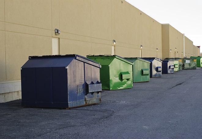 tilted front-load dumpsters being emptied by waste management workers in Dorchester Center MA